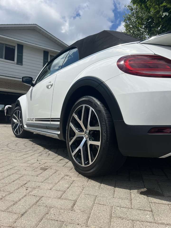 Polished machined-face wheel on a white Beetle